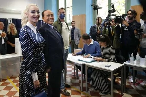  Silvio Berlusconi, leader of center-right, populist Forza Italia is flanked by his partner Marta Fascina, after casting his ballot at a polling station in Milan, Italy, Sunday, Sept. 25, 2022, in Milan, Italy.  Just in time to celebrate his 86th birthday, Italy’s former premier Silvio Berlusconi is making his return to Italy's parliament, winning a seat in the Senate nearly a decade after being banned from public office over a tax fraud conviction. (AP Photo/Antonio Calanni, File)