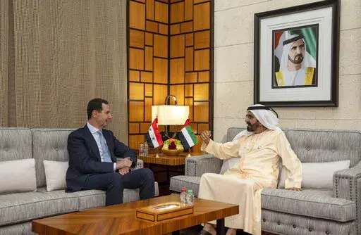 In this photo released by the official Facebook page of the Syrian Presidency, Syrian President Bashar Assad, left, meets with Sheikh Mohammed bin Rashid Al Maktoum, vice president and prime minister of the UAE and the ruler of Dubai, in Dubai, United Arab Emirates, Friday, March 18, 2022. Assad travelled to the United Arab Emirates, marking his first visit to an Arab country since Syria's civil war erupted in 2011, his office said Friday. (Syrian Presidency Facebook page via AP)