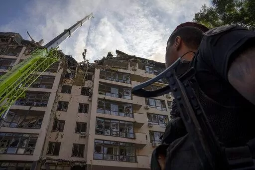 Servicemen work at the scene at a residential building following explosions, in Kyiv, Ukraine, Sunday, June 26, 2022. Several explosions rocked the west of the Ukrainian capital in the early hours of Sunday morning, with at least two residential buildings struck, according to Kyiv mayor Vitali Klitschko. (AP Photo/Nariman El-Mofty)