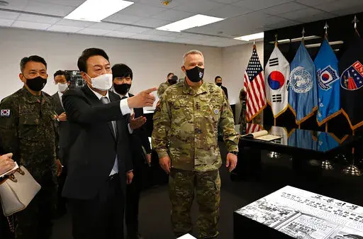 In this photo provided by South Korean President-elect office via Yonhap News Agency, South Korean President-elect Yoon Suk Yeol, second from left, speaks as Gen. Paul LaCamera, right, commander of USFK and the South Korea-U.S. Combined Forces Command, listens during his visit to Camp Humphreys in Pyeongtaek, South Korea, on April 7, 2022. Yoon takes office as South Korea's president Tuesday, May 10 amid heightened animosities over North Korea's nuclear program. During his election campaign, the
