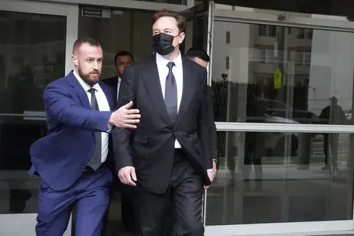 Elon Musk, center, leaves a federal courthouse in San Francisco, Friday, Feb. 3, 2023. A high-profile trial focused on a 2018 tweet about the financing for a Tesla buyout that never happened drew a surprise spectator for Friday's final arguments — Elon Musk, the billionaire who is being accused of misleading investors with his usage of the Twitter service he now owns. (AP Photo/Jeff Chiu)