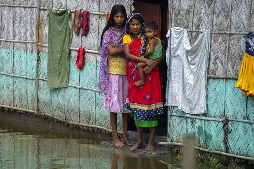 A flood affected family waits for the help at marooned Tarabari village, west of Gauhati, in the northeastern Indian state of Assam, Monday, June 20, 2022. Authorities in India and Bangladesh are struggling to deliver food and drinking water to hundreds of thousands of people evacuated from their homes in days of flooding that have submerged wide swaths of the countries. The floods triggered by monsoon rains have killed more than a dozen people, marooned millions and flooded millions of houses. 