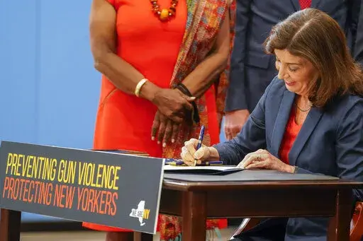 New York Gov. Kathy Hochul signs a package of bills to strengthen gun laws, Monday, June 6, 2022, in New York. New York has strengthened gun laws as part of a series of laws signed this week by Gov. Kathy Hochul with the hope to lessen gun violence and gun-related deaths. Hochul, a Democrat, signed 10 gun-related bills Monday. (AP Photo/Mary Altaffer)