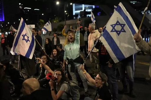 Protesters attempt to block a street during a demonstration to demand the release of the hostages taken by Hamas militants into the Gaza Strip during the Oct. 7th attack, in Tel Aviv, Israel, Saturday Jan. 20, 2024. After the Oct. 7 attack by Hamas, Israelis put aside their differences and rallied behind the war effort in Gaza. But as the war grinds on, the mood of the Israeli public is shifting and old divisions are reemerging. The catalyst is a rift over the polarizing leadership of Israeli Pr