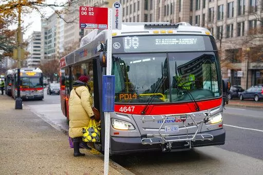 A passenger is seen boarding a Metrobus in downtown Washington, Wednesday, Dec. 7, 2022. The Washington DC government voted to waive fares for Metrobus rides within city limits starting July, 1, 2023, becoming the nation's most populous city to offer free public transit. (AP Photo/Pablo Martinez Monsivais)