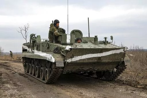 An armored vehicle rolls outside Mykolaivka, Donetsk region, the territory controlled by pro-Russian militants, in eastern Ukraine, Sunday, Feb. 27, 2022. Fighting also raged in two eastern territories controlled by pro-Russia separatists. (AP Photo)