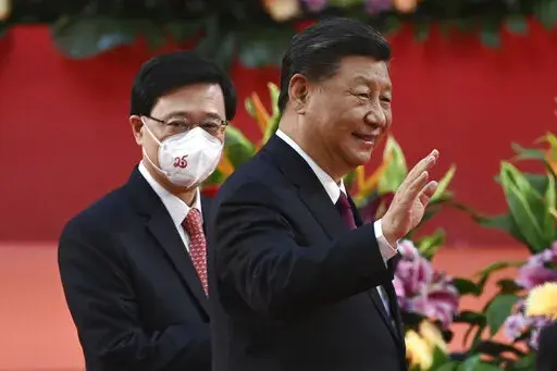 Hong Kong's new Chief Executive John Lee, left, walks with China's President Xi Jinping following Xi's speech after a ceremony to inaugurate the city's new leader and government in Hong Kong Friday, July 1, 2022, on the 25th anniversary of the city's handover from Britain to China. (Selim Chtayti/Pool Photo via AP)