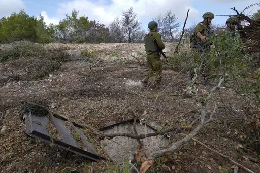 Israeli soldiers display what they say is an entrance to a Hezbollah tunnel found during their ground operation in southern Lebanon, near the border with Israel, Sunday, Oct. 13, 2024. (AP Photo/Sam McNeil)