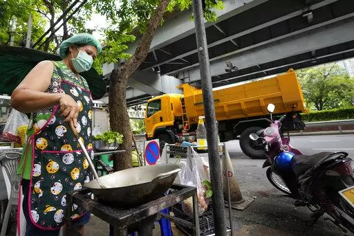 Street food vendor Warunee Deejai cooks lunch for customers in Bangkok, Thailand, Thursday, Aug. 11, 2022. In the six months since Russia invaded Ukraine, the fallout from the war has had huge effects on the global economy. Though intertwined with other forces, the war has made problems like inflation much worse for people around the world. In Bangkok, rising costs for pork, vegetables and oil have forced Warunee Deejai, a street-food vendor, to raise prices, cut staff and work longer hours. (AP