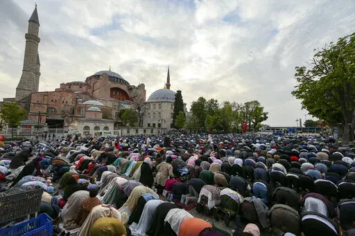 Muslims offer prayers during the first day of Eid al-Fitr, which marks the end of the holy month of Ramadan outside the iconic-historic Haghia Sophia Mosque in Istanbul, Turkey, Monday, May 2, 2022. (AP Photo/Emrah Gurel)
