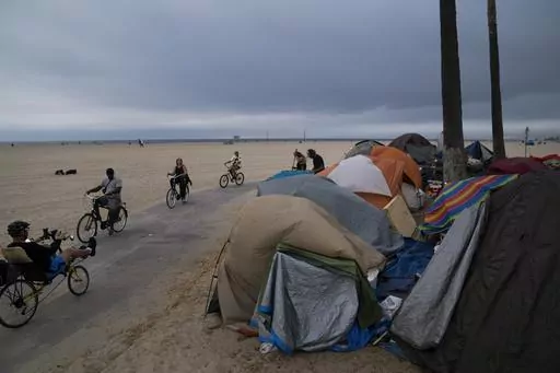 People ride their bikes past a homeless encampment set up along the boardwalk in the Venice neighborhood of Los Angeles on June 29, 2021. Democratic Mayor Karen Bass, who was elected in November 2023 after promising to take on the city’s out-of-control homeless crisis, announced Monday, April 17, she would recommend spending what she called a record $1.3 billion next year to get unhoused people into shelter and treatment programs. (AP Photo/Jae C. Hong, File)
