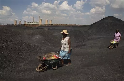 Women push wheelbarrows atop a coal mine dump at the coal-powered Duvha power station, near Emalahleni east of Johannesburg, Nov. 17, 2022. Humanity still has a chance, close to the last one, to prevent the worst of climate change’s future harms, a top United Nations panel of scientists said Monday, March 20, 2023. But doing so requires quickly slashing carbon pollution and fossil fuel use. (AP Photo/Denis Farrell, File)
