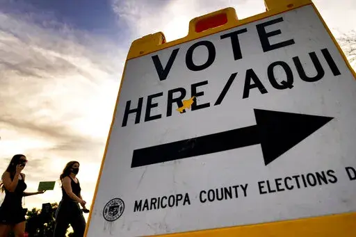 In this Nov. 3, 2020, file photo, voters deliver their ballot to a polling station in Tempe, Ariz. A review of potential voter fraud cases in the 2020 general election in Arizona's second-largest county ended, Friday, Jan. 14, 2022, with an announcement by prosecutors that none of the 151 cases they reviewed merited criminal charges. The findings in Pima County provide yet another official rebuttal to former President Donald Trump's claims that voter fraud led to his loss in Arizona and other ba