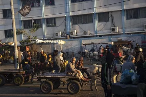 Palestinians ride donkey carts during the ongoing Israeli bombardment of the Gaza Strip in Khan Younis on Friday, Nov. 17, 2023. (AP Photo/Fatima Shbair)