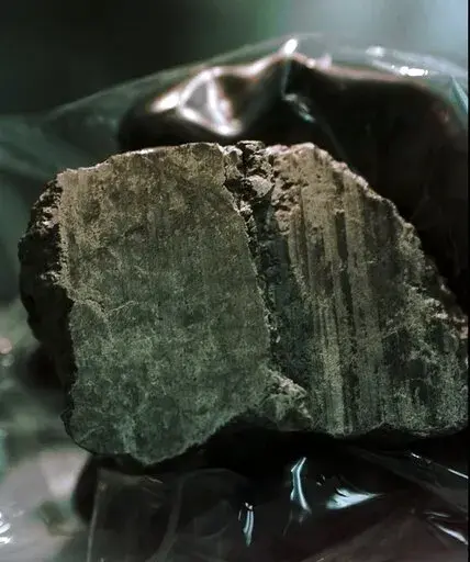 The meteorite labeled ALH84001 is held in the hand of a scientist at a Johnson Space Center lab in Houston, Aug. 7, 1996. Scientists say they've confirmed the meteorite from Mars contains no evidence of ancient Martian life. The rock caused a splash 25 years ago when a NASA-led team announced that its organic compounds may have been left by living creatures, however primitive. Researchers chipped away at that theory over the decades. A team of scientists led by Andrew Steele of the Carnegie Inst