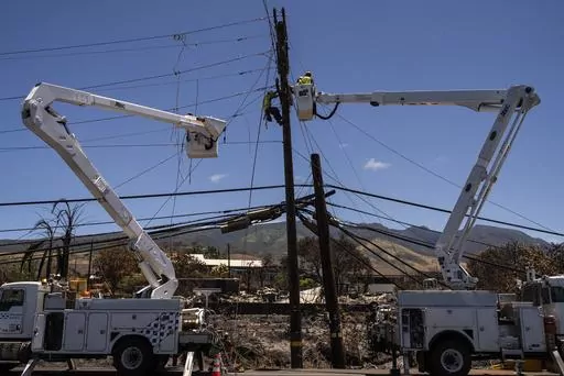 Electric crews work on power lines in the aftermath of a devastating wildfire in Lahaina, Hawaii, Thursday, Aug. 17, 2023. Lawyers for Lahaina residents and business owners told a court Tuesday, Sept. 5, that cable TV and telephone companies share in responsibility for the wildfires that devastated the island. (AP Photo/Jae C. Hong, File)