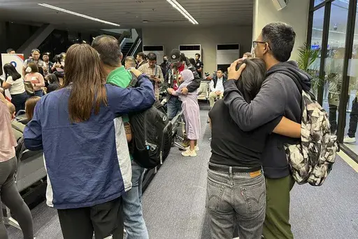 In this photo released by Department of Migrant Workers, freed Filipino crew-members, who were among those taken hostage aboard the Galaxy Leader in Yemen, are welcomed by family as they arrive at Manila's International Airport on Thursday, Jan. 23, 2025. (Department of Migrant Workers via AP)