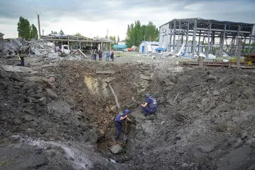 Police members inspect a crater caused by a Russian rocket attack in Pokrovsk, Donetsk region, Ukraine, Wednesday, June 15, 2022. (AP Photo/Efrem Lukatsky)