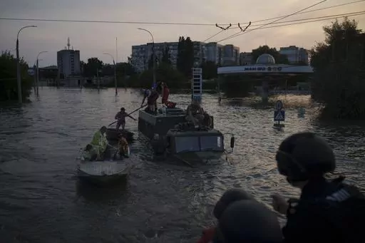 Residents are evacuated from a flooded neighborhood in Kherson, Ukraine, Tuesday, June 6, 2023. A major dam in southern Ukraine has collapsed, flooding villages, endangering crops in the country's breadbasket and threatening drinking water supplies. (AP Photo/Felipe Dana)