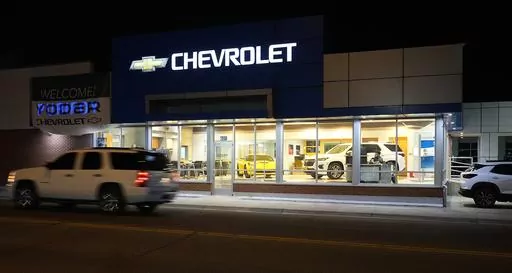 FILE- A a vehicle passes a Chevrolet dealership in Fort Lupton, Colo. Many car shoppers neglect a key factor that can help save money: getting the best value for their trade-in vehicle. (AP Photo/David Zalubowski)