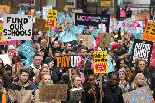 Thousands of demonstrators wave banners as they stand near Downing Street in Westminster in London, Wednesday, Feb. 1, 2023. Up to half a million workers are expected to go on strike across the U.K. in what's shaping up to be the biggest day of industrial action Britain has seen in more than a decade. Thousands of schools will close some or all of their classrooms, train services will be paralyzed and delays are expected at airports as teachers, university staff, civil servants, border officials