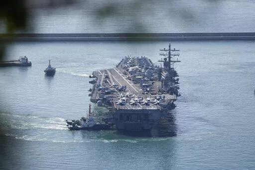 U.S. aircraft carrier USS Ronald Reagan is escorted into Busan Naval Base in Busan, South Korea, Friday, Sept. 23, 2022. The USS Ronald Reagan arrived to participate in  upcoming joint military drills with South Korea in the East Sea – the first time since 2017. (AP Photo/Lee Jin-man)