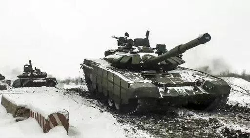 In this grab taken from video provided by the Russian Defense Ministry Press Service on Wednesday, Jan. 26, 2022, a Russian tanks roll during a military exercising at a training ground in Rostov region, Russia. The Kremlin, which has denied having any invasion plans, has scoffed at an argument that it wants to see the ground frozen to launch an attack on Ukraine. Ukrainian officials agree that the mud isn't an issue. (Russian Defense Ministry Press Service via AP, File)