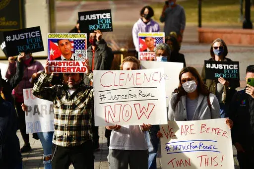 People hold signs in support of truck driver Rogel Aguilera-Mederos during a rally on the west steps of the state capitol Wednesday, Dec. 22, 2021 in Denver. Relatives, lawmakers and other supporters of a trucker sentenced to 110 years in prison after an explosive brake-failure accident that left four people dead rallied in Denver to plead for clemency. (Helen H. Richardson/The Denver Post via AP)