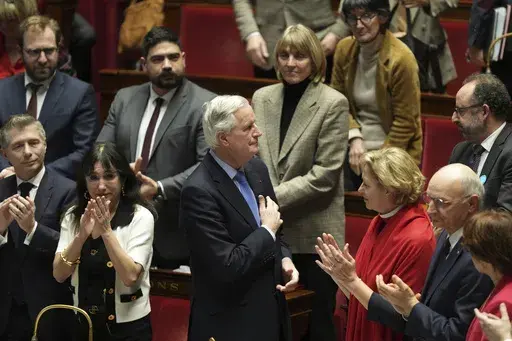 French Prime Minister Michel Barnier gets applause from ministers and parliament members after addressing the National Assembly prior to a vote on a no-confidence motion that could bring him down and his cabinet for the first time since 1962, Wednesday, Dec. 4, 2024 in Paris. (AP Photo/Michel Euler)