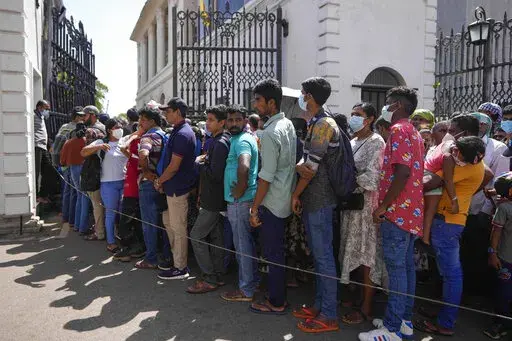 People queue up to enter the official residence of president Gotabaya Rajapaksa three days after it was stormed by anti government protesters in Colombo, Sri Lanka, Tuesday, July 12, 2022. Rajapaksa had vacated the building before the protesters came in. (AP Photo/Eranga Jayawardena)