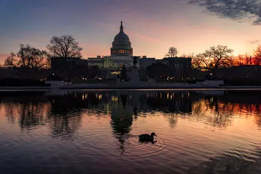 The sun rises behind the Capitol in Washington, early Wednesday, Dec. 14, 2022. Congressional leaders have unveiled a $1.7 trillion spending package early Tuesday, Dec. 20, 2022, that includes another large round of aid to Ukraine, a nearly 10% boost in defense spending and roughly $40 billon to assist communities across the country recovering from drought, hurricanes and other natural disasters. (AP Photo/J. Scott Applewhite, File)