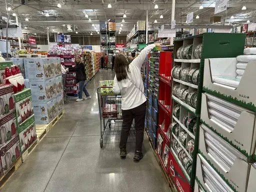 Shoppers reach for items on display in a Costco warehouse Nov. 19, 2024, in Lone Tree, Colo. (AP Photo/David Zalubowski, File)