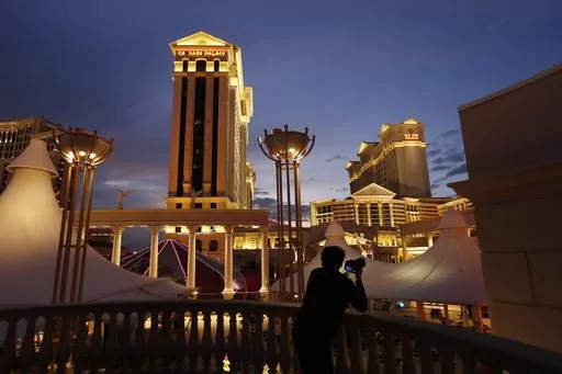 A man takes pictures of Caesars Palace hotel and casino in Las Vegas, Jan. 12, 2015. Casino company Caesars Entertainment has joined Las Vegas gambling giant MGM Resorts International in reporting a recent cyberattack. But while MGM Resorts computer systems were still down, Caesars told federal regulators on Thursday, Sept. 14, 2023, that its casino and online operations were not disrupted. (AP Photo/John Locher, File)