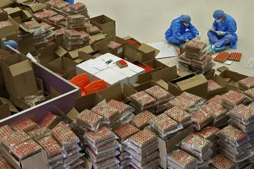 Health workers from mainland China record thousands of samples from Hong Kong residents to be tested for the coronavirus at an inflatable mobile testing lab in Hong Kong Tuesday, March 1, 2022. Hong Kong has ramped up its testing capacity with the help of the mobile laboratories, as the city grapples with tens of thousands of COVID-19 cases daily. (AP Photo/Vincent Yu)