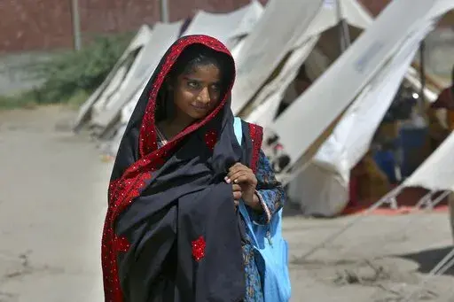 Flood victim Rajul Noor walks towards her tent school at a relief camp, in Dadu, a district of southern Sindh province, Pakistan, Sept. 23, 2022. Every part of Noor’s life has been wrecked by this summer’s massive monsoon-driven floods. The 12-year-old girl’s family home is destroyed, as is the school that she loved. The devastation wreaked by floods in Pakistan this summer has intensified the debate over a question of climate justice: Do rich countries whose emissions are the main cause o