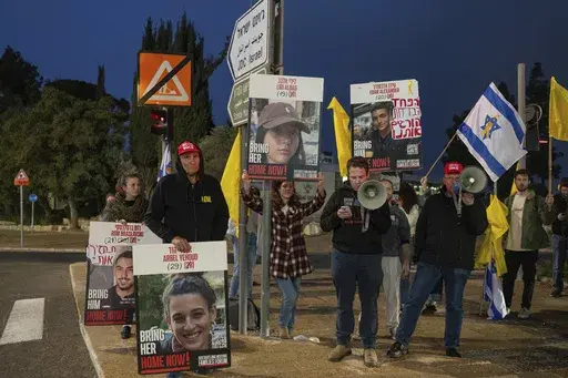 Israeli demonstrators outside the prime minister's office in Jerusalem hold photos of Liri Albag and other hostages during a protest calling for their release from being held in the Gaza Strip by the Hamas militant group, Sunday, Jan. 5, 2025. (AP Photo/Ohad Zwigenberg)