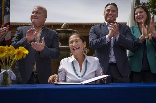 Interior Secretary Deb Haaland smiles after signing Public Land Order 7940, which protects more than 4,200 acres of Bureau of Land Management-managed public lands that is sacred to Tribes in the Placitas area, during a community event at El Zócalo Plaza in Bernalillo, N.M., Thursday, April 18, 2024. For the next 50 years, the lands will be closed to new mining claims, mineral sales, and oil and gas leases. (Chancey Bush/The Albuquerque Journal via AP)