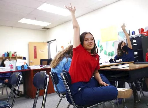 Lilianna Naizer-Baldwin,10, foreground center, raises her hand during her Spanish class at the New Mexico International School in Albuquerque, N.M., on Friday, May 27, 2022. Mary Baldwin a psychology intern at UNM Hospital Health science Center immigrated to the U.S. form Honduras when she was 10. Now her daughter Lilianna is the same age, and thanks to the dual language program she's fluent enough to cook banana-leaf-wrapped tamales with her Spanish-speaking grandmother. New Mexico is the only 