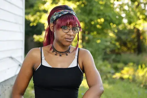 Monica Eberhart sits outside her home Thursday, Aug. 25, 2022, in Columbus, Ohio. Eberhart had to travel to Indianapolis, Ind., for an abortion after Ohio imposed a ban on abortions once fetal heart activity could be detected. (AP Photo/Jay LaPrete)