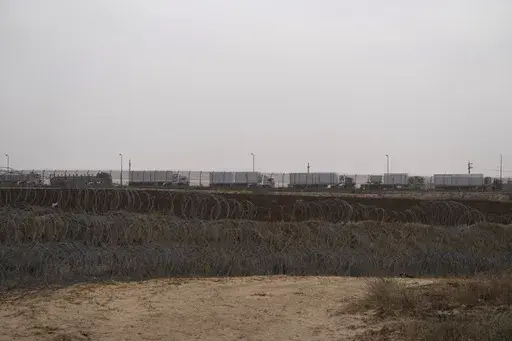 Trucks, carrying humanitarian supplies for the Gaza Strip, wait in line on the Egyptian side, at the Kerem Shalom Crossing border as seen from southern Israel, on April 25, 2024. An influx of aid appears to have eased a hunger crisis in northern Gaza for now, but the entire territory remains at “high risk” of famine after Israel's offensive in Rafah caused massive displacement and the disruption of aid operations in the south, a draft report said Monday. (AP Photo/Leo Correa, File)