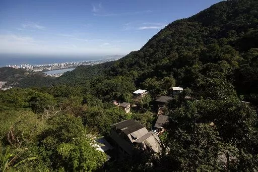 Houses in the Enchanted Valley sustainable community stand on the outskirts of Tijuca National Forest in Rio de Janeiro, Brazil, Monday, June 6, 2022. Electricity arrived in the late 20th century to the low-income Enchanted Valley community, but the utility never connected it to the city’s sewage network, so its residents set out to solve the problem on its own by building a biodigester and artificial wetland to process all sewage generated by all of its 40 families. (AP Photo/Bruna Prado)