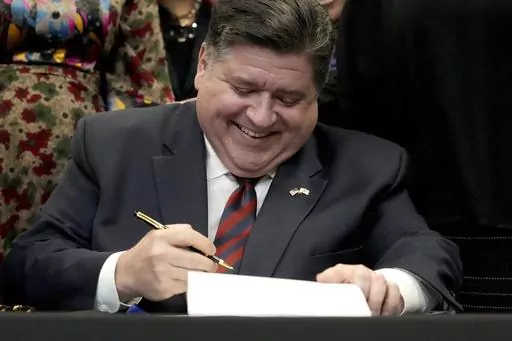 Illinois Gov. J.B. Pritzker signs into law the Paid Leave For All Workers Act on Monday, March 13, 2023, in Chicago. Illinois became one of three U.S. states to require employers to offer paid time off for any reason starting in January of 2024. (AP Photo/Charles Rex Arbogast)