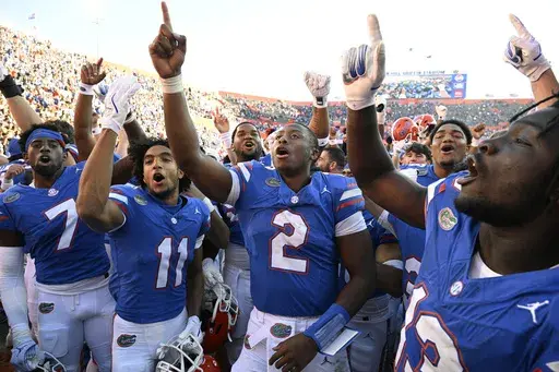 Florida quarterback DJ Lagway (2) and teammates Trikweze Bridges (7), Aidan Mizell (11) and Jadan Baugh (13) celebrate their 24-17 win against Mississippi in an NCAA college football game, Saturday, Nov. 23, 2024, in Gainesville, Fla. (AP Photo/Phelan M. Ebenhack)