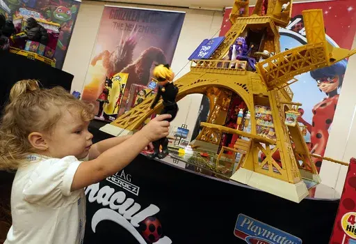 Reggie Rose Geschke, 2, plays with the Miraculous Paris Heroes Playset, from Playmates Toys, at the TTPM 2024 Holiday Showcase event, in New York, Sept. 17, 2024. (AP Photo/Richard Drew, File)