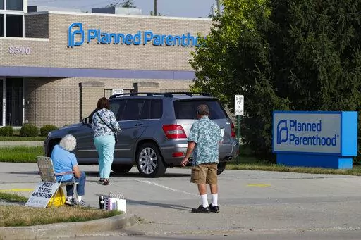 Abortion protesters attempt to hand out literature as they stand in the driveway of a Planned Parenthood clinic in Indianapolis, Aug. 16, 2019. Hospitals and abortion clinics in Indiana are preparing for the state's abortion ban to go into effect on Sept. 15, 2022. Starting Sept. 15, abortions will be permitted only in cases of rape and incest, before 10-weeks post-fertilization; to protect the life and physical health of the patient; and if a fetus is diagnosed with a lethal anomaly. The law al