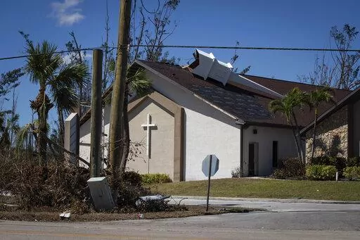 The steeple lays on its side atop Southwest Baptist Church in Fort Myers, Fla., on Sunday, Oct. 2, 2022. The church sustained heavy wind and flooding damage during Hurricane Ian as parishioners took refuge in the sanctuary. (AP Photo/Robert Bumsted)