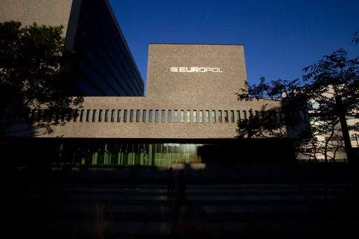 FILE- This Wednesday, Oct. 10, 2018, file photo shows the sun bouncing off the Europol headquarters in The Hague, Netherlands. Europol says law enforcement authorities in six different countries have joined forces to take down a “super cartel” of drugs traffickers controlling about one third of the cocaine trade in Europe. (AP Photo/Peter Dejong, File)