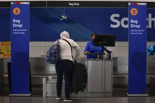 A Southwest Airlines traveler checks a bag at Midway International Airport, Tuesday, March 11, 2025, in Chicago. (AP Photo/Erin Hooley)