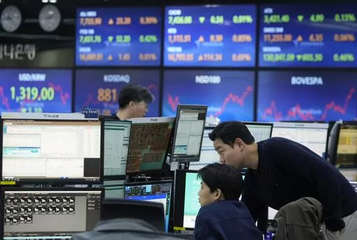 Currency traders watch monitors at the foreign exchange dealing room of the KEB Hana Bank headquarters in Seoul, South Korea, on Jan. 11, 2024. Asia markets mostly advanced Friday, Jan. 19, after Wall Street recouped most of the week's earlier losses and Japan reported slowing inflation, which may keep its ultra-low interest rates steady. (AP Photo/Ahn Young-joon, File)