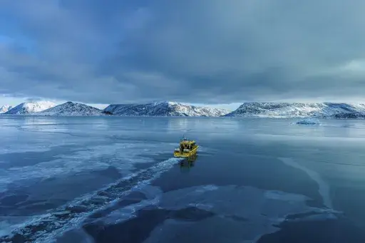 A boat rides though a frozen sea inlet outside of Nuuk, Greenland, March 6, 2025. (AP Photo/Evgeniy Maloletka)